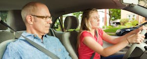 Un père et sa fille adolescente conduisent une voiture ensemble