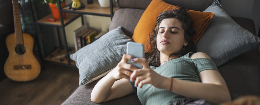 Young woman using smart phone at home.