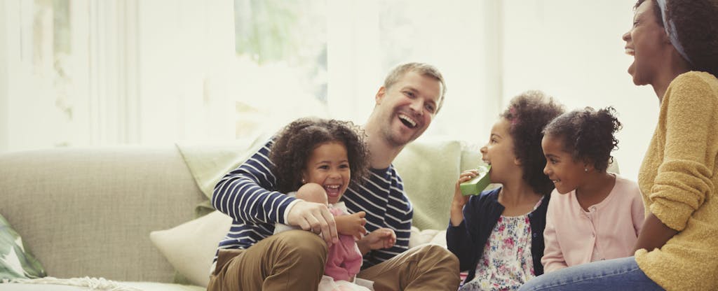 Young family laughing on sofa